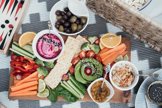 Dips and cut vegetables on a wooden board