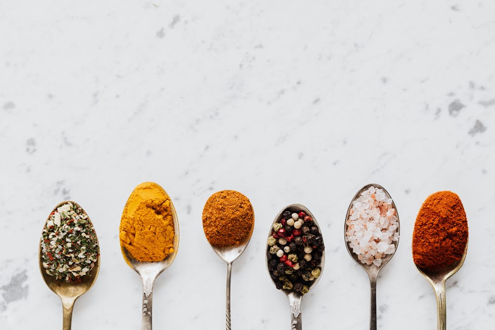 Spoonfuls of spices, pepper and salt