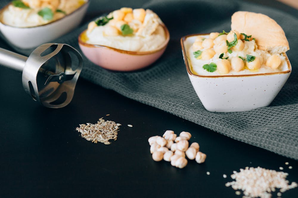 Three small bowls of homemade hummus